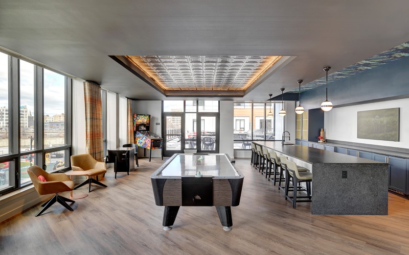 A pool table with seating areas and large windows